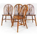 A set of four 20thC oak wheel back dining chairs, with shaped seats on turned legs each joined by