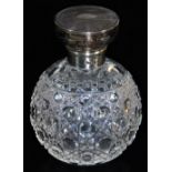 An early 20thC cut glass perfume bottle, with engine turned silver lid, 10cm high.