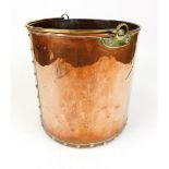 An early 20thC copper coal bucket, of cylindrical studded form with swing brass handle, the main