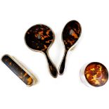 A George V silver and tortoise shell dressing table set, comprising hand mirror 23cm high, clothes