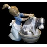 A Lladro figure of a girl brushing dog, no. 5455, printed marks beneath, 12cm high.