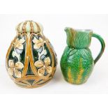 An early 20thC Majolica jug, in a green and yellow floral pattern with plain beak spout and