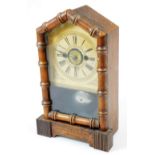 An early 20thC pine cased alarm clock, with turreted top and quarter bamboo finish front revealing a