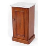 A Victorian mahogany pot cupboard, with later marble top raised above a panelled door on D end base,