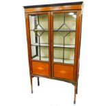 An Edwardian mahogany display cabinet, with an inlaid bell flower and bow frieze above two