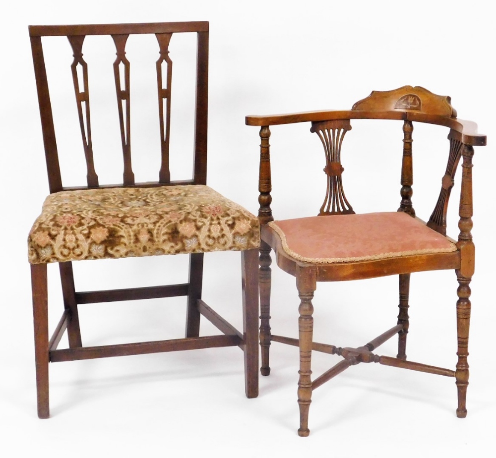An Edwardian mahogany corner chair, with shaped overstuffed seat on turned legs joined by an X