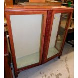 A mid 20thC shaped display cabinet on compressed cabriole pad feet, 125cm high.