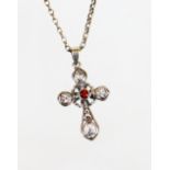 A cross pendant of shaped form, set with red stone, 4cm high, attached to a slender link necklace,