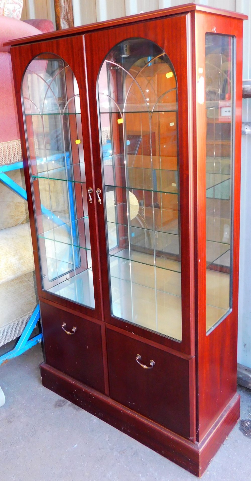 A glazed display cabinet, with arched doors, 161cm high.