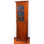 An Edwardian mahogany freestanding corner display cabinet, with fixed moulded cornice raised above