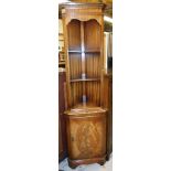 A mahogany and flame mahogany finish freestanding corner cupboard with dentil top, open shelves