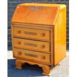 A mid 20thC oak bureau, with carved fall front, raised above three long drawers on shaped feet, 76cm