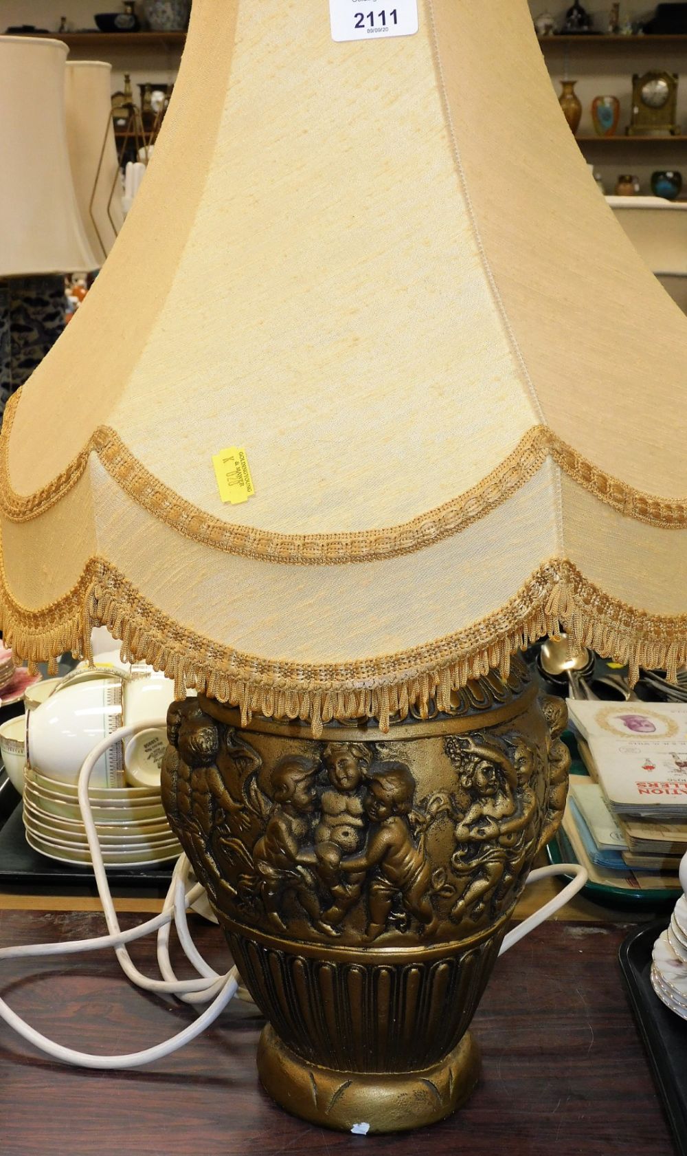 A decorative classical style lamp, with yellow shade.