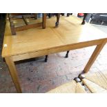 A light oak finish extending dining table, of rectangular form, on heavy block legs, 74cm high,