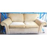 A three seater lounge sofa, in geometric cream coloured material with tassel section beneath,