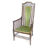 An Edwardian Arts & Crafts style armchair, with a spindle turned back, side supports and stretchers,