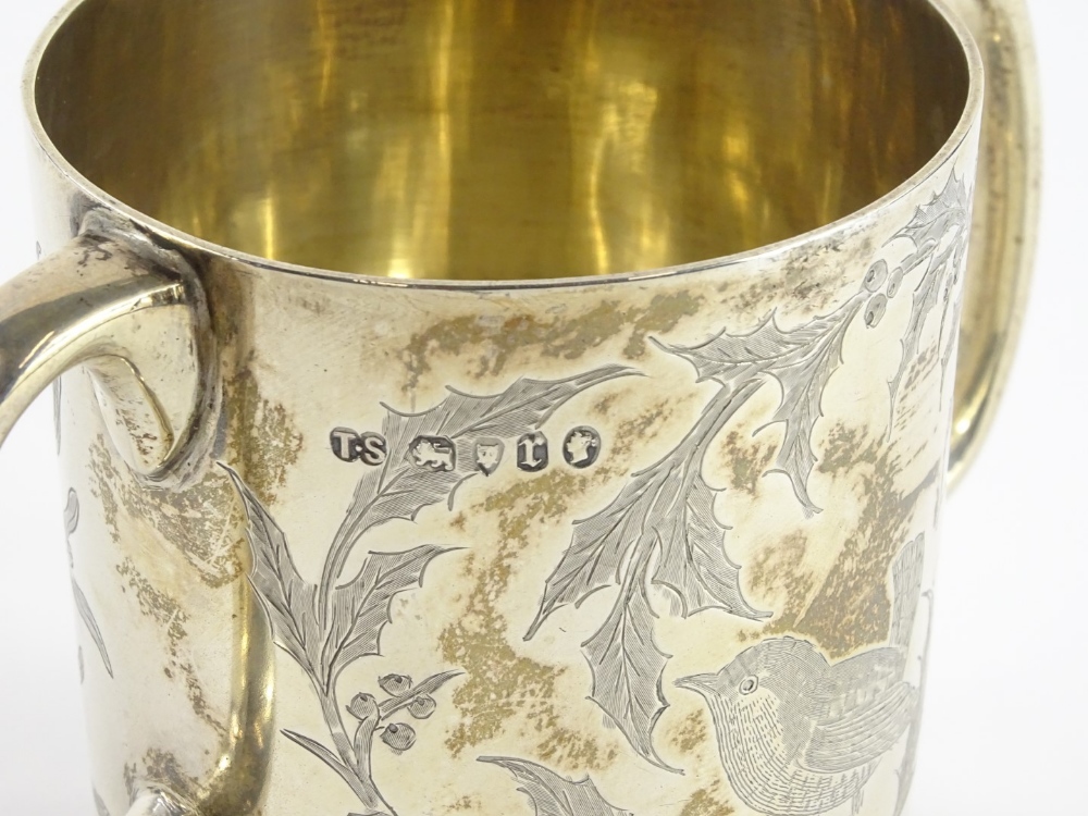 A Victorian silver two handled christening mug, engraved with a bird, seated on a branch of holly, - Image 2 of 2