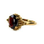 A 9ct gold dress ring, set with oval garnet, in four claw setting, with fan design outer border,