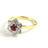 An 18ct gold ruby and diamond cluster ring, with central ruby 3.2mm diameter, surrounded by six