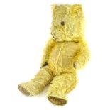 A vintage teddy bear, with velvet pads (AF), label to reverse stating Made in England, 53cm long