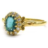 An emerald and diamond cluster ring, the central oval emerald 7.5mm x 5.5mm, approx 0.9cts