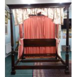 A mahogany four post bed in George III style, with panelled head board, the front posts with