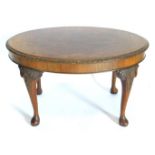 A walnut and burr walnut oval coffee table, with a carved border and on cabriole legs, with pad