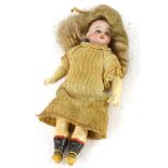 A late 19th/early 20thC German bisque headed small doll, with papier mache limbs etc., 13cm high.