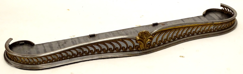 A 19thC steel and gilt brass serpentine shaped fire curb or fender, 145cm wide.