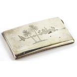 An Eastern silver coloured metal rectangular cigarette case, engraved with buildings, palm trees,