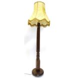 A mahogany bed post standard lamp, with a pleated shade, the lamp itself with a reeded column,