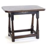 An unusual oak low table, the canted rectangular top on turned supports, with plain stretchers,