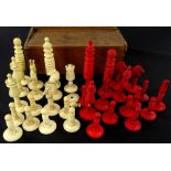 A late 19thC carved bone chess set, part stained red, height of King 9cm high.