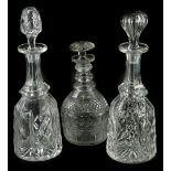 Two similar cut glass decanters, each with a slender neck and associated stopper and a triple ring