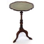 A mahogany wine table, the circular dished top with a shaped edge and green leather inset, on turned