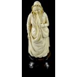A 19thC carved ivory figure of a lady wearing a bonnet and a long dress, possibly Dieppe, on an