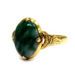 A modern jade set dress ring, the oval jade with pale and dark green striations, in a four claw