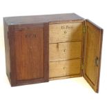 An unusual 19thC oak wall mounted cabinet, the two panelled doors written with the initials FCM,