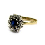 A 9ct gold cluster ring, set with central oval cut sapphire in gold eight claw setting, surrounded