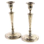 A pair of early Victorian silver candlesticks, each with a reeded sconce, fluted tapering column and