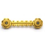 A Victorian bar brooch, with reeded and dot design, set with a single seed pearl at each end, yellow