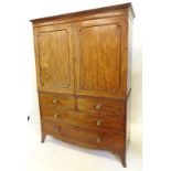 An early 19thC mahogany clothes press, the top with a moulded cornice above two panelled doors,