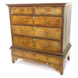 An 18thC walnut chest on stand, the top with a moulded cornice with two short and three long cross