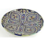 An Isnik pottery charger, decorated with four ovals in a quatrefoil design embellished with flowers,