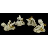 A set of four continental porcelain piano type putti, each picked out in gilt, printed marks to