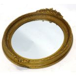 A late 19th/early 20thC oval gilt gesso wall mirror, decorated with flowers, leaves etc., 82cm x