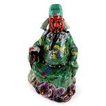 A Chinese porcelain figure of an emperor or immortal, holding a scroll, decorated in yellow,