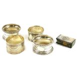 A collection of small silver, to include four napkin rings and a match holder, cast with putti.