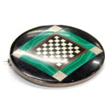 An oval malachite and black onyx set brooch, with central diamond hatched decoration, in a white