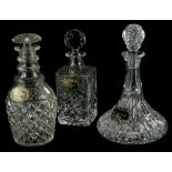 Three cut glass decanters, a ship's decanter and stopper with label, a triple ring necked decanter